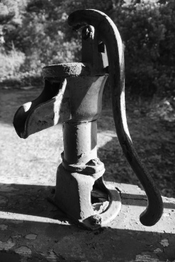 The hand pump for the well is still mounted and plumbed on the front porch though long ago the property had city water plumbed in.